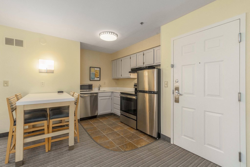 a kitchen with stainless steel appliances and a table and chairs